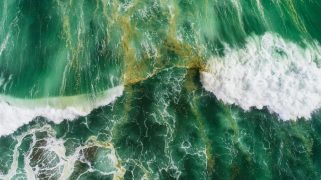 Aerial view of waves splashing in sea.