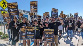 Amazon drivers at a picket line with signs that say, "Make Amazon Deliver $30 an hour"