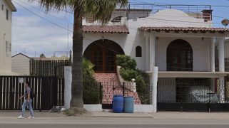 A person walking in front of a home in Baja California
