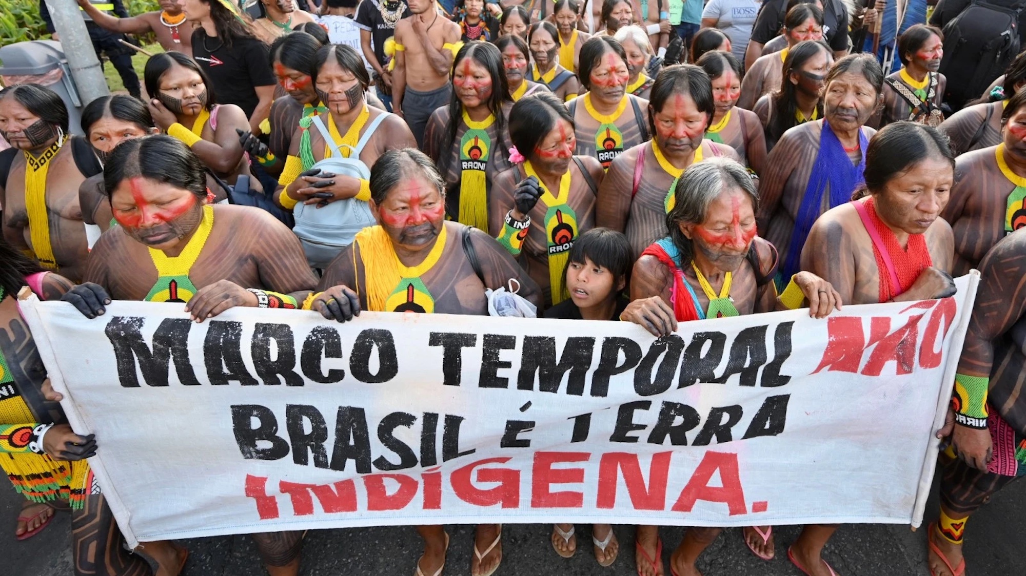 Indigenous people marching with a sign that says "Marco Tempora"