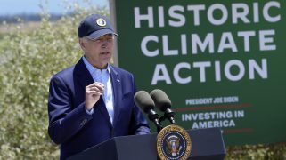 Biden speaking at a podium outside, next to a sign that says, "Historic Climate Action"