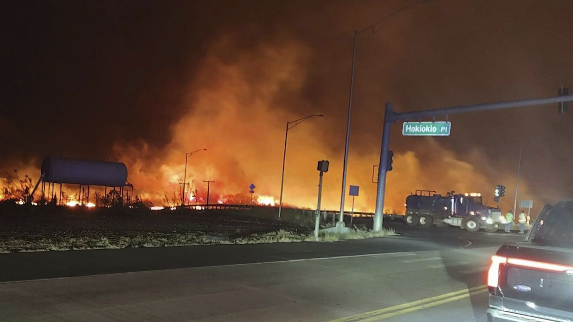 This photo provided by County of Maui shows fire and smoke filling the sky from wildfires on the intersection at Hokiokio Place and Lahaina Bypass in Maui, Hawaii.