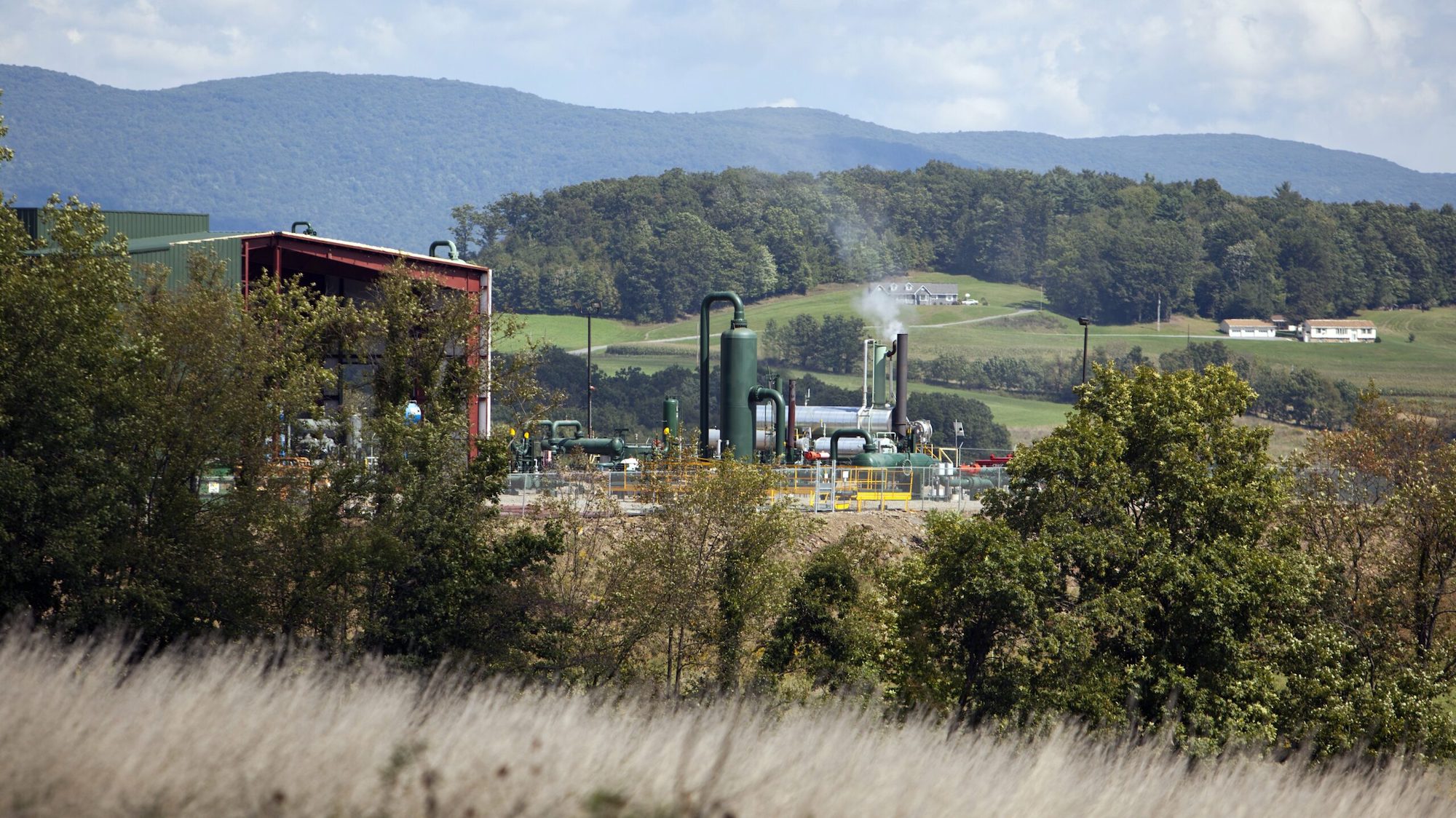 PENN TOWNSHIP, PA - SEPTEMBER 9: A natural gas compressor station sits on a hillside September 9, 2012 in Penn Township, Pennsylvania. The area is situated above the Marcellus Shale where drilling for natural gas and hydrofracking occurs. Hydrofracking is a controversial drilling method which pumps millions of gallons of water, sand and chemicals into horizontally drilled wells to stimulate the release of the gas. The Marcellus Shale gas field stretches diagonally across West Virginia, Ohio, Pennsylvania and New York State. Drilling operations have provided Pennsylvania with billions of dollars of income through employment and tax revenue. The environmental impact is a politically sensitive issue in a resource dependent state. (Photo by Robert Nickelsberg/Getty Images)