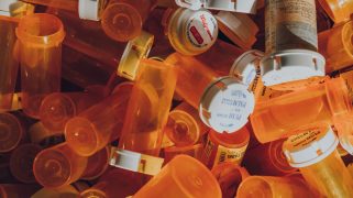 A stack of empty orange bill bottles on top of each other