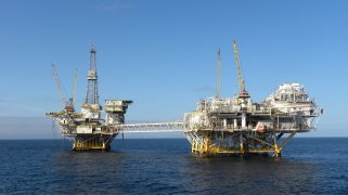 Two offshore drilling platforms in the ocean.