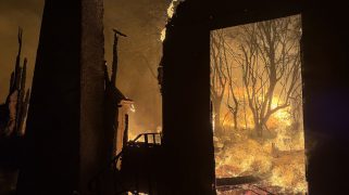 A blackened structure engulfed in flames