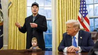 Two white men and one child in the oval office.
