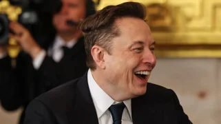 A white man (Elon Musk) laughs.