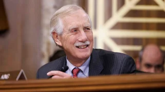 A white man with a white mustache and hair.