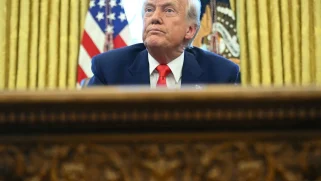 A white man looks over his desk