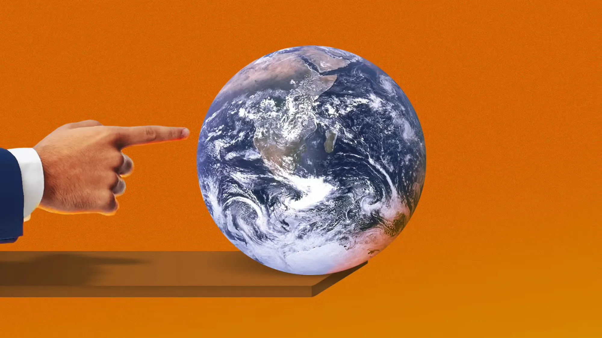 Earth on orange background. Hand pointing to it.