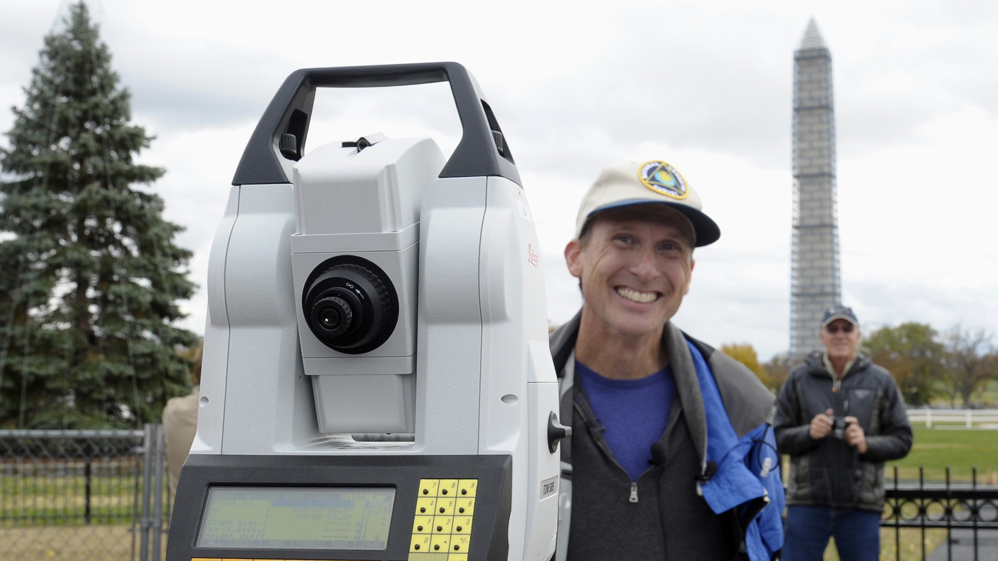 A man stands near a measuring device smiling