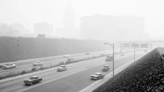 A black and white photo of a smoggy street.