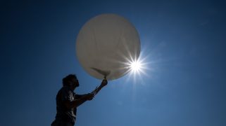 A picture taken on September 7, 2023 shows meteorologist Laurent Moullet preparing to launch a weather balloon measuring the zero degree isotherm at MeteoSwiss station in Payerne, western Switzerland. On last August 21, 2023, as hot spell enveloping Europe, MeteoSwiss said a new zero-degree isotherm record was set at 5,298 metres above the sea level, "which constitutes a record since monitoring began in 1954". The previous record of 5,184 metres was set on July 25, 2022. Because of its major influence on vegetation development, snowfall limits and the water cycle, the zero degree isotherm plays a key role in weather forecasting and in everyday life in the Alpine region. (Photo by Fabrice COFFRINI / AFP) (Photo by FABRICE COFFRINI/AFP via Getty Images)