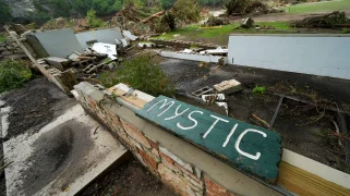 A wrecked building with a "mystic" sign