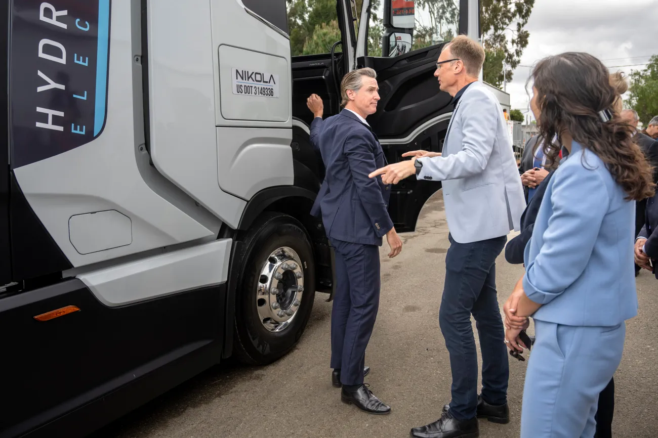 Michael Lohscheller, president and CEO of Nikola Corporation, shows Gov. Gavin Newsom one of his company's electric big-rigs in Paramount, California, May 1, 2023.