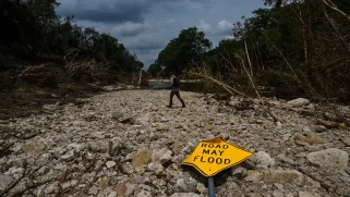 A fallen sign that says "road may flood"