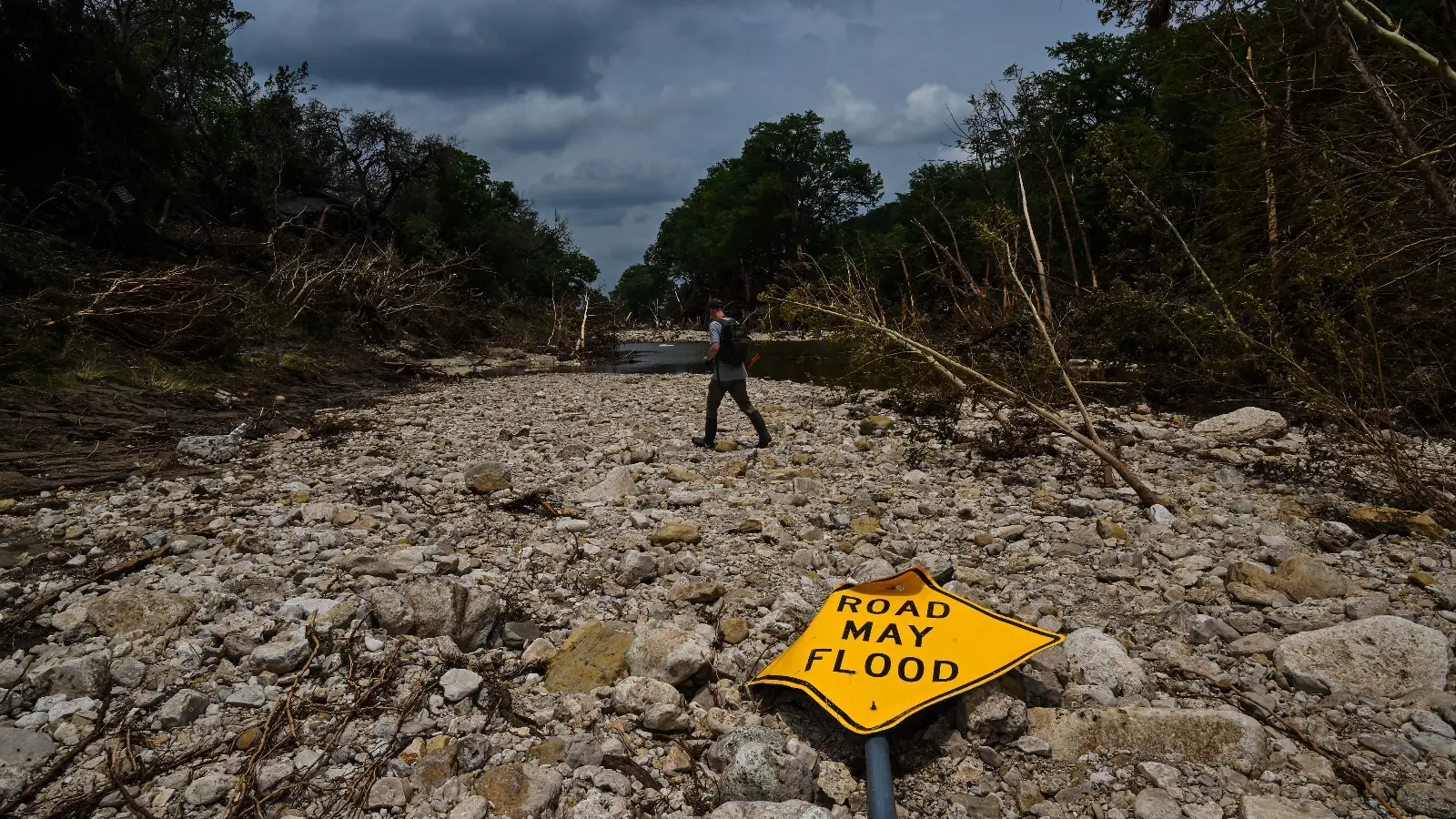 A fallen sign that says "road may flood"