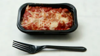Lasagna in a black plastic container