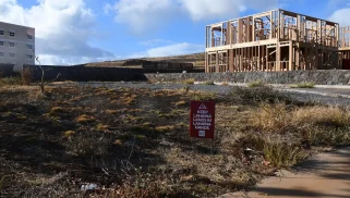 An empty lot with the sign "Keep Lāhainā in Lāhainā Hands"