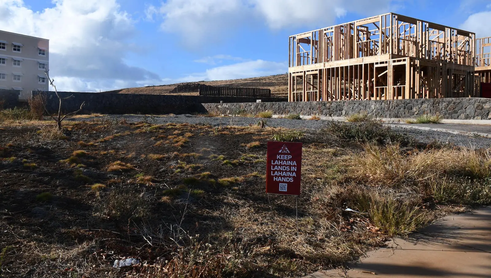 An empty lot with the sign "Keep Lāhainā in Lāhainā Hands"