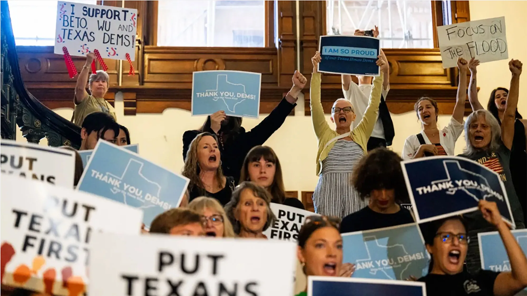 Supporters cheer Democratic state representatives as they return to the Texas House on August 18, 2025 holding signs.