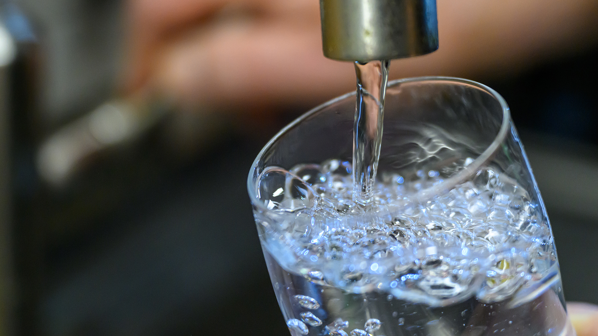 PRODUCTION - 24 July 2025, Saxony, Chemnitz: Drinking water runs into a glass in a kitchen in Chemnitz. The energy supplier Eins operates the city's drinking water network, which is around 1500 kilometers long.